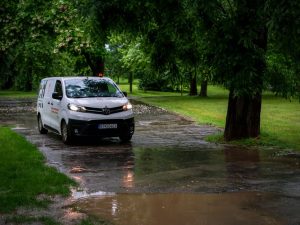 White van driving on a wet park road on a rainy day in Bratislava, Slovakia.
